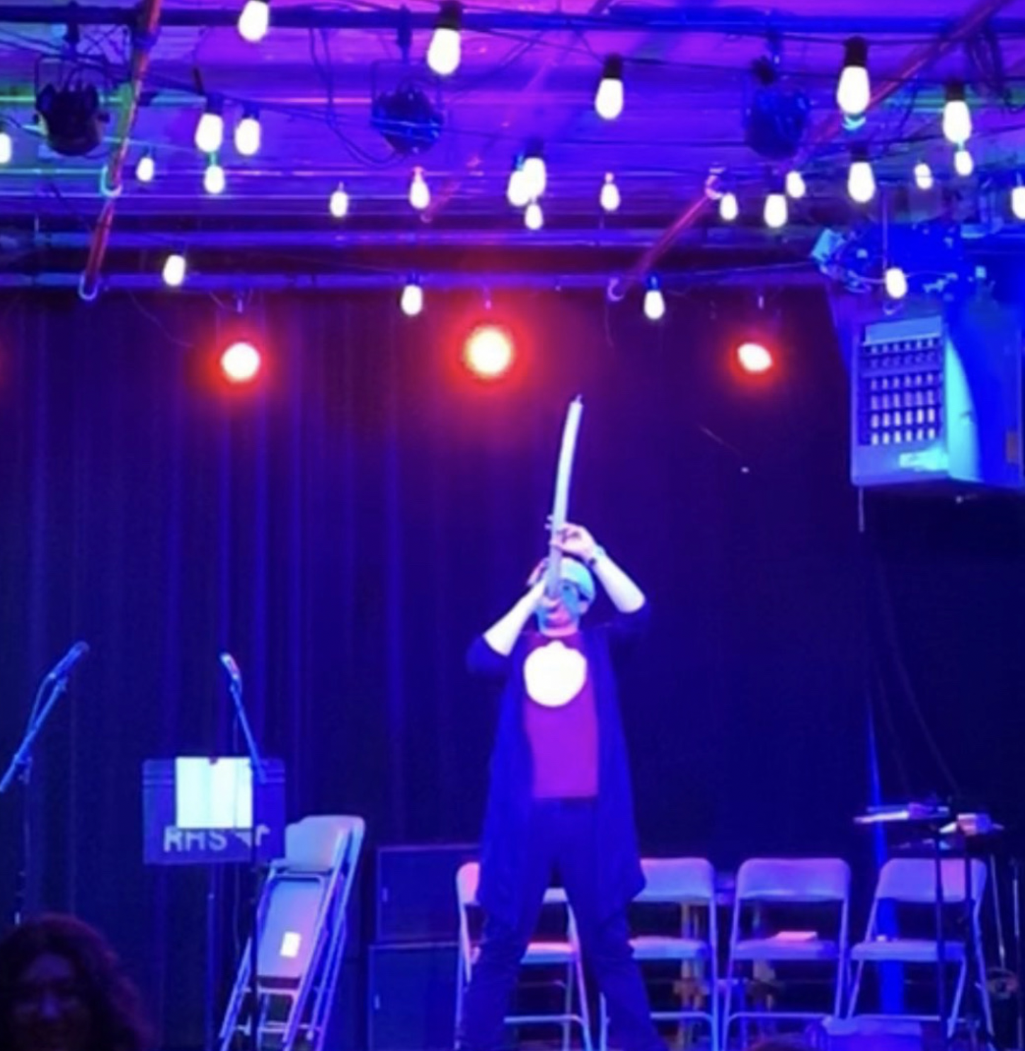 Marko performing on a stage under blue and violet lights